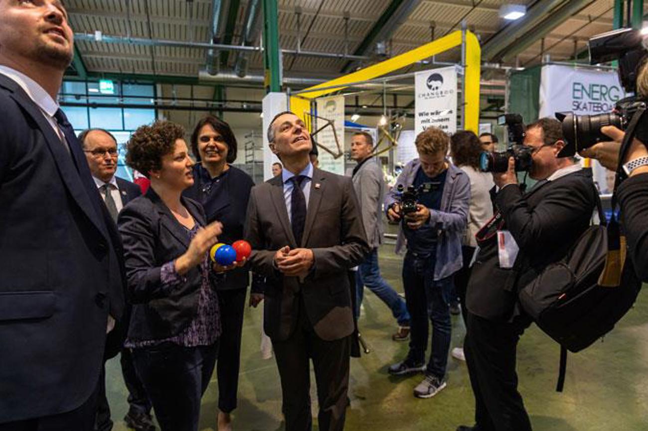 Bundesrat Ignazio Cassis besuchte letztes Jahr auf seinem muba-Rundgang auch den Stand der Kirchen. Hier lässt er sich zusammen mit der Basler Regierungspräsidentin Elisabeth Ackermann von Stephanie Krieger, Leiterin Fachstelle Kommunikation der reformierten Kirche Baselland, erklären, wie der «Wunschturm» mit den farbigen Bällen funktioniert.|muba Basel