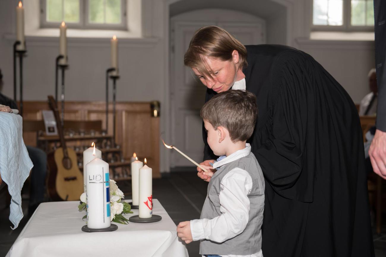 Vielleicht einer der schönsten Momente im Pfarramt: Ein Kind wird getauft, und sein Bruder zündet für es eine Kerze an.
Bild zvg